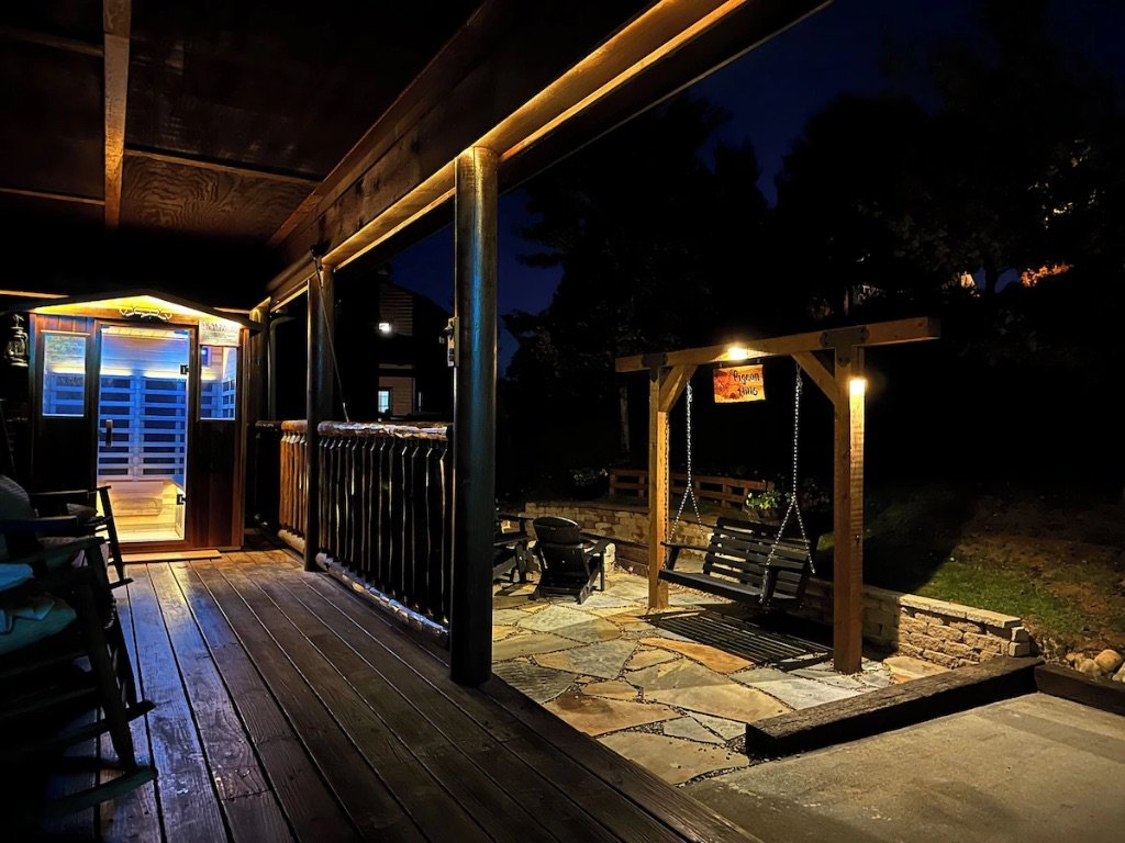 Pigeon Hills deck at night with hot tub fire pit and ambient cabin lighting Smoky Mountains