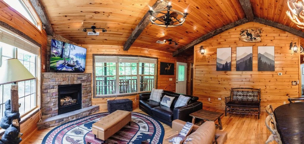 Pigeon Hills living room with stone fireplace vaulted ceilings leather couches and mountain artwork